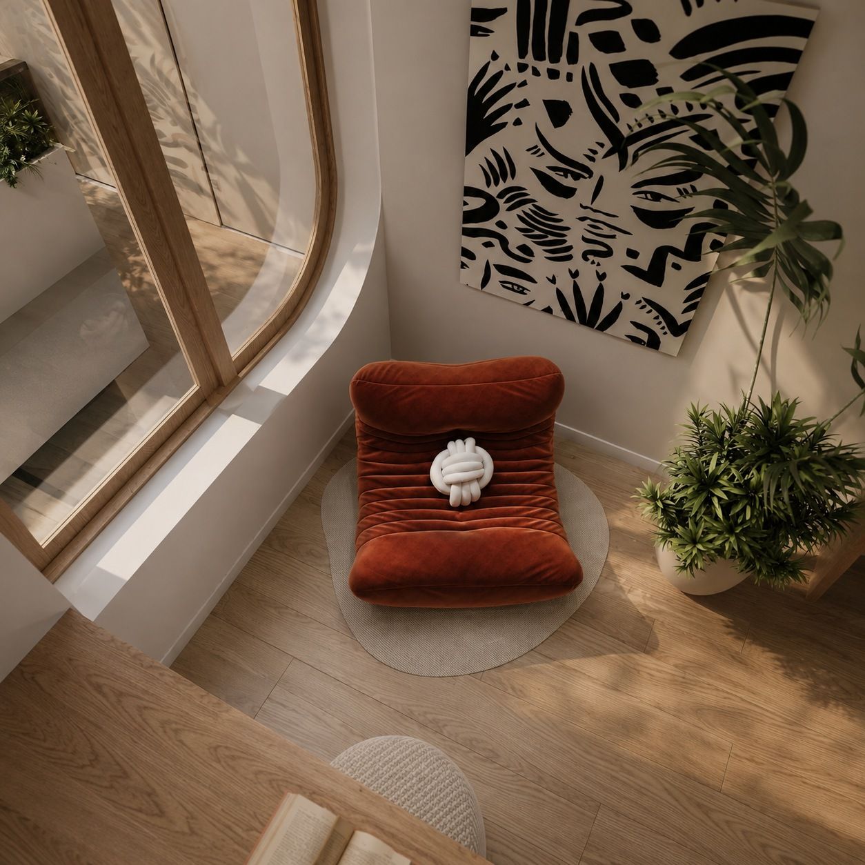 Rust-red velvet reading chair by a curved window, seen from above